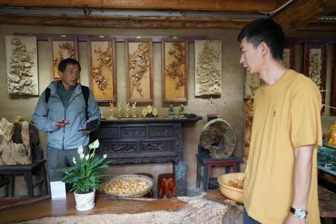 樹新木雕體驗(yàn)館的老板小羅與顧客交談